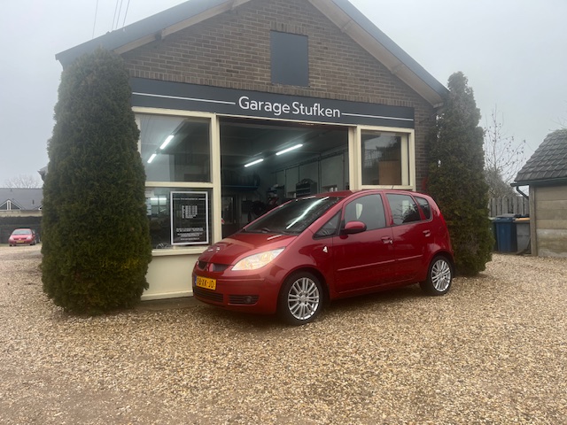 Rode Mitsubishi Colt voor de gevel van Garage Stufken