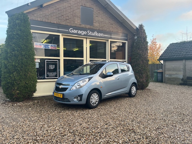 Lichtblauwe Chevrolet Spark voor de gevel van Garage Stufken